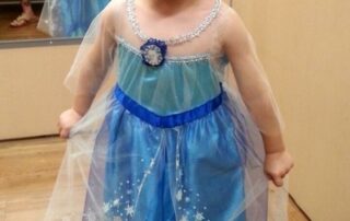 boy dressed in a blue Elsa character outfit